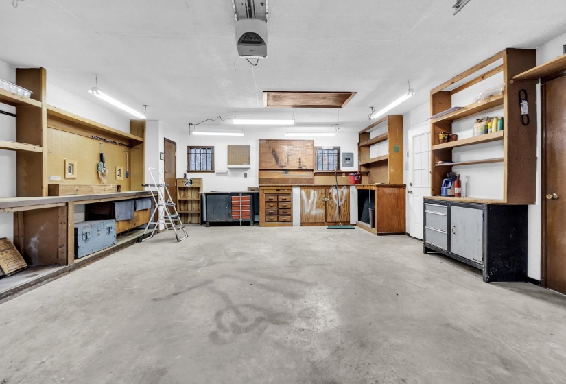 Garage featuring a garage door opener and a workshop area