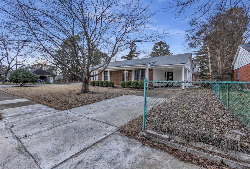 Ranch-style house featuring an attached carport, driveway, a porch, and brick siding