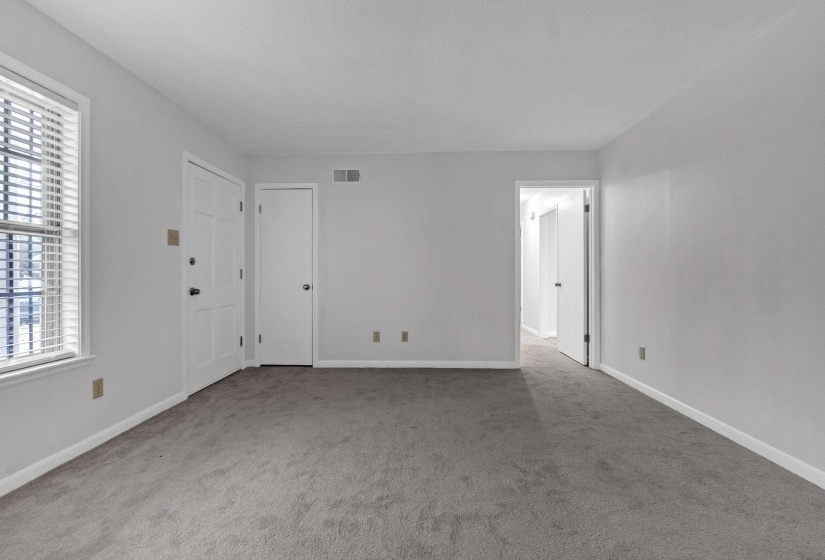 Empty room with baseboards and light colored carpet