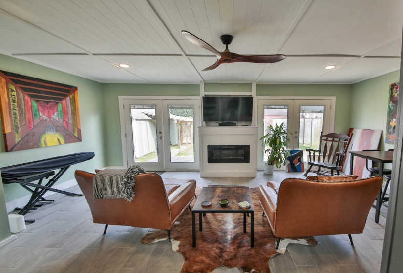 Living area with wooden ceiling, light wood finished floors, a glass covered fireplace, and recessed lighting