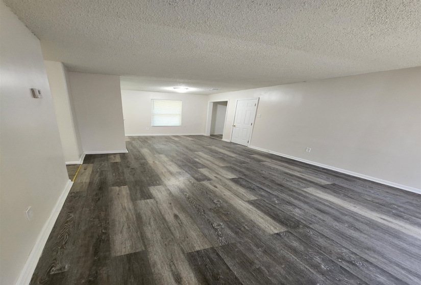 Empty room featuring dark hardwood / wood-style floors and a textured ceiling