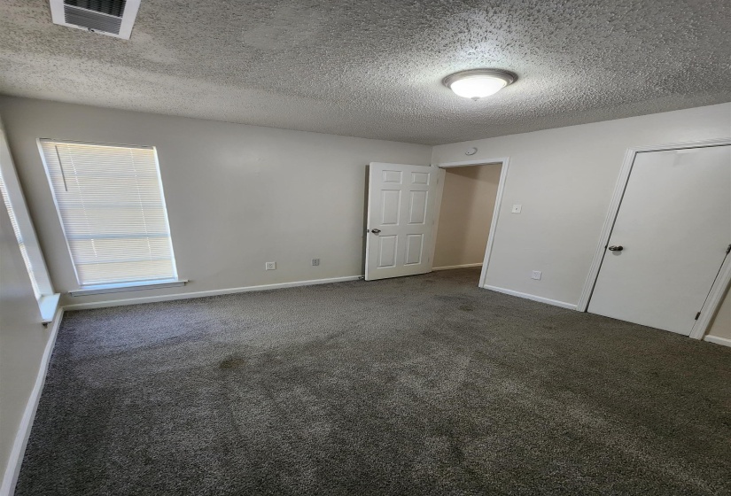 Interior space with carpet flooring and a textured ceiling