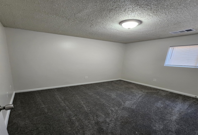 Carpeted empty room featuring a textured ceiling