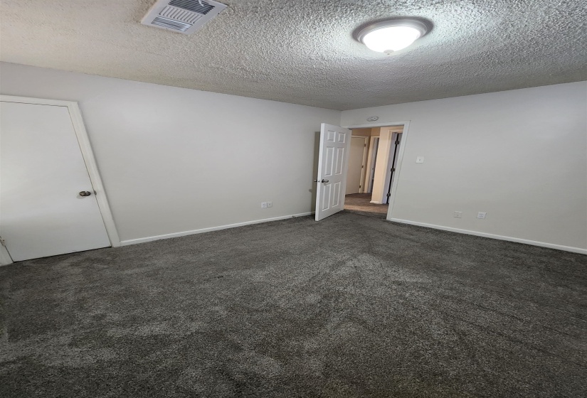 Carpeted spare room with a textured ceiling