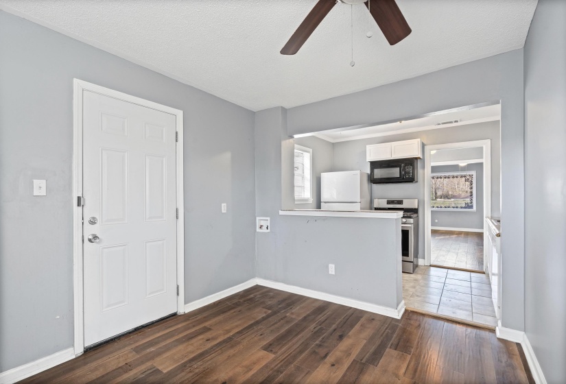 Unfurnished living room featuring dark wood-type flooring, a ceiling fan, a textured ceiling, and plenty of natural light