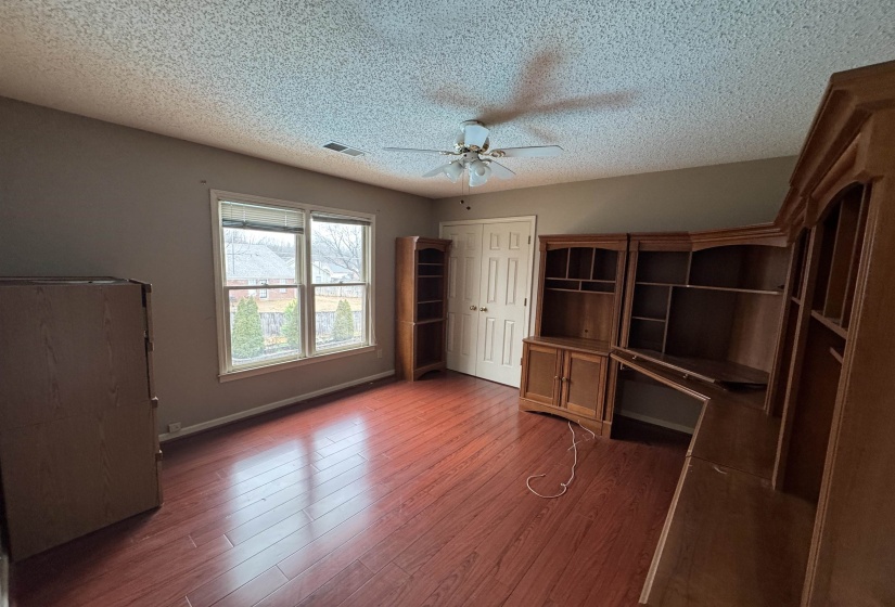 Unfurnished bedroom featuring wood finished floors, a ceiling fan, a textured ceiling, and a closet