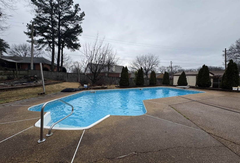 View of pool with a fenced backyard, a patio, and a diving board
