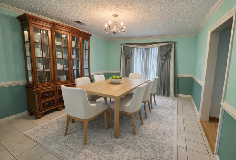 Dining space with a textured ceiling, ornamental molding, and a chandelier