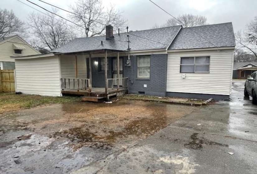 Rear view of property with a chimney, a shingled roof, and a wooden deck