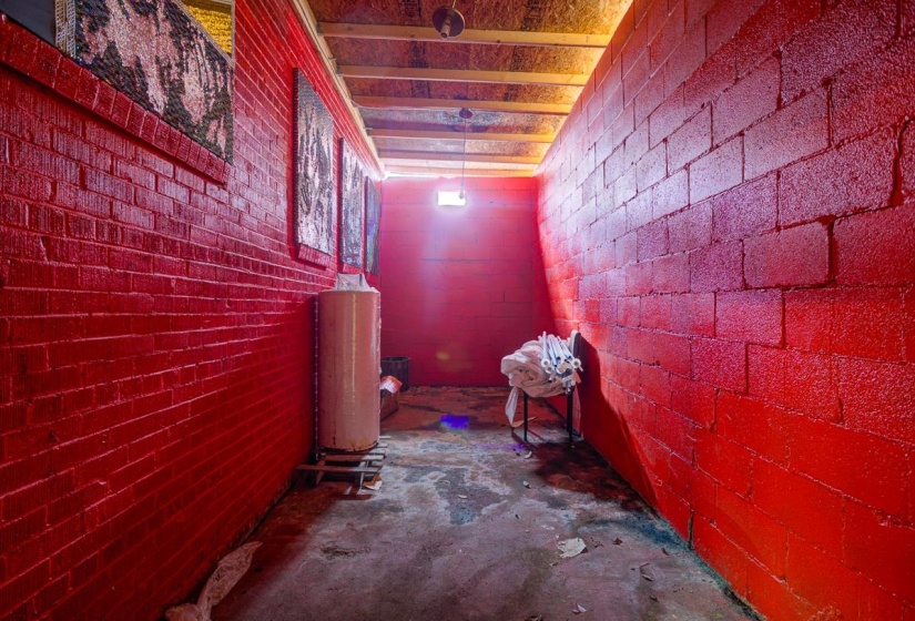 Hallway featuring unfinished concrete floors and concrete block wall