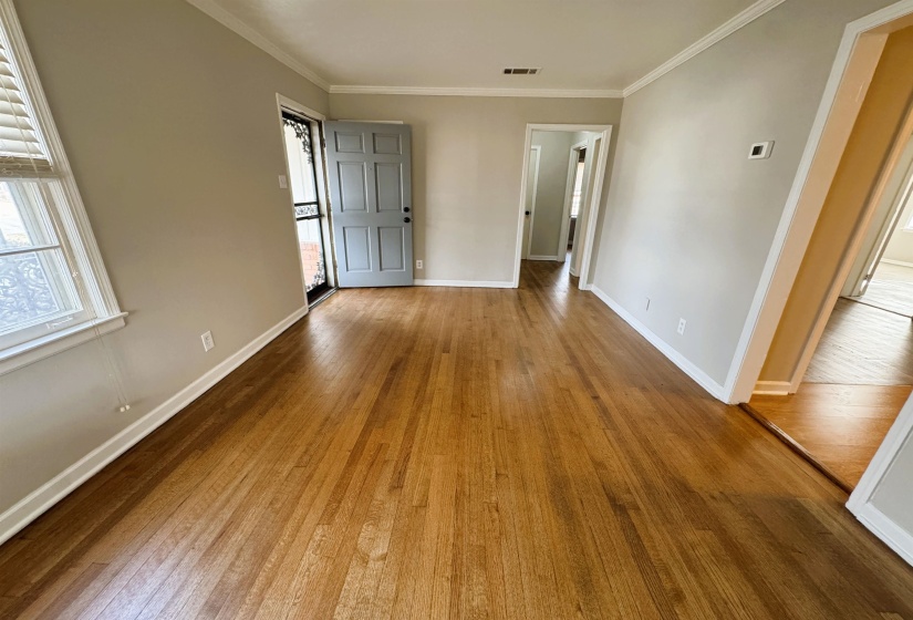 Empty room featuring hardwood / wood-style floors and ornamental molding