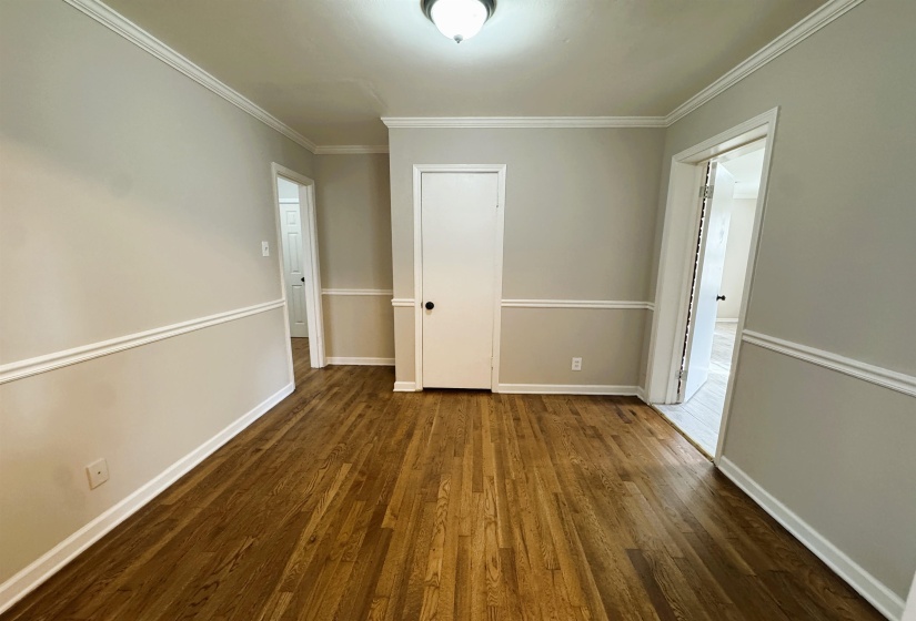 Unfurnished room featuring dark wood-type flooring and crown molding
