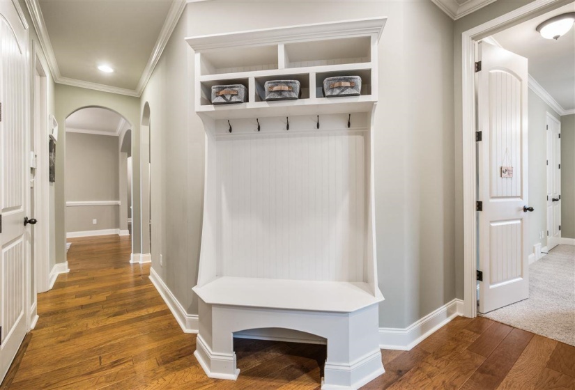 Mudroom featuring crown molding, arched walkways, dark wood-style flooring, and recessed lighting