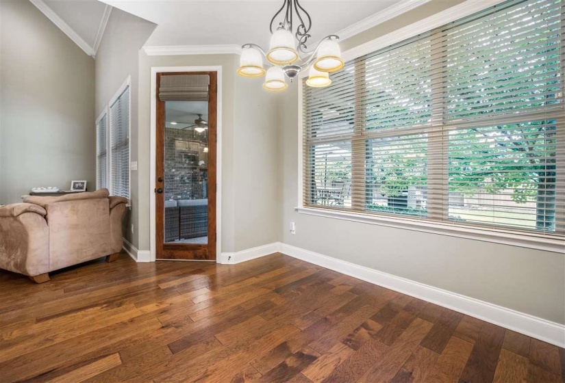 Unfurnished dining area featuring dark wood-style flooring, crown molding, a chandelier, and a ceiling fan