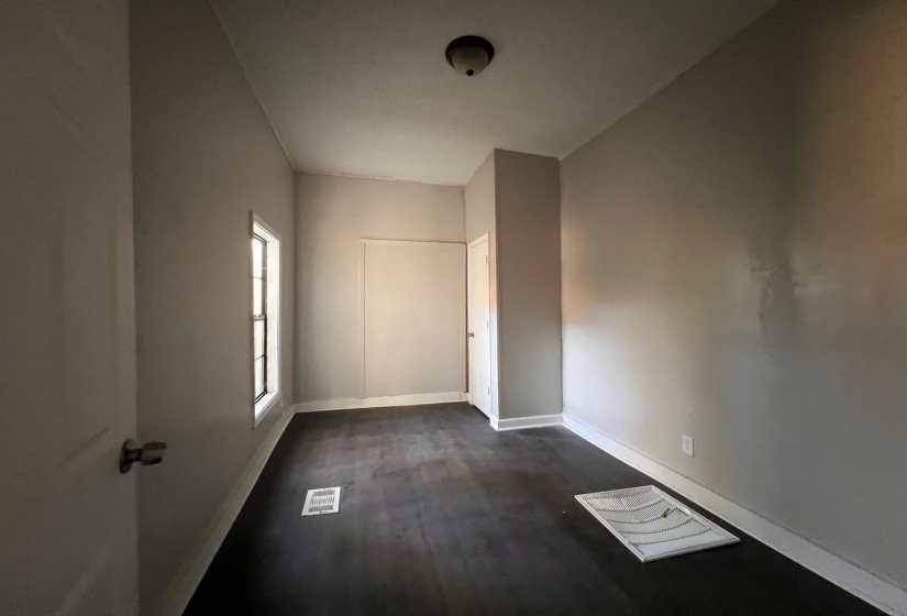Empty room featuring baseboards and dark wood finished floors