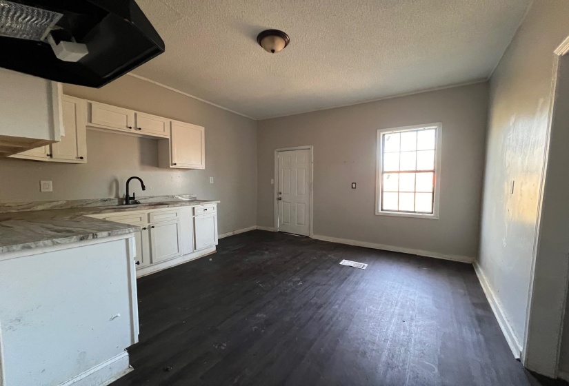 Kitchen featuring white cabinetry, light countertops, a textured ceiling, and dark wood-style flooring