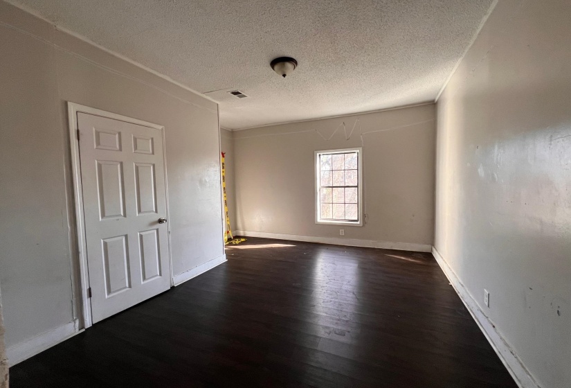 Unfurnished room with dark wood-type flooring and a textured ceiling