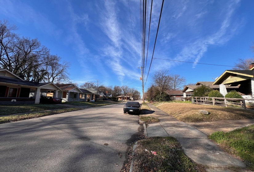 View of asphalt street featuring a residential view and sidewalks