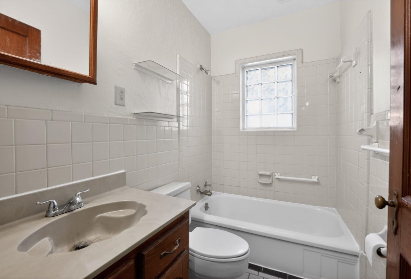 Bathroom with vanity,  shower combination, and tile walls