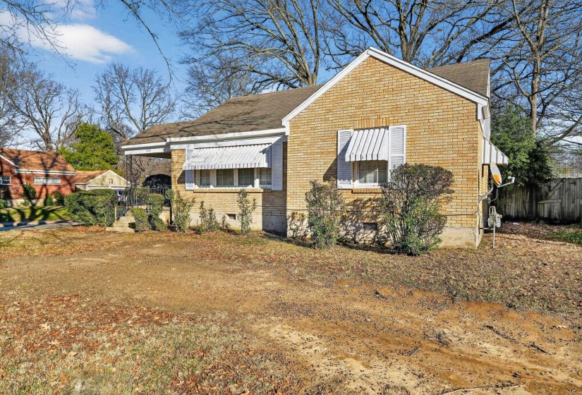 View of side of home with brick siding and roof with shingles