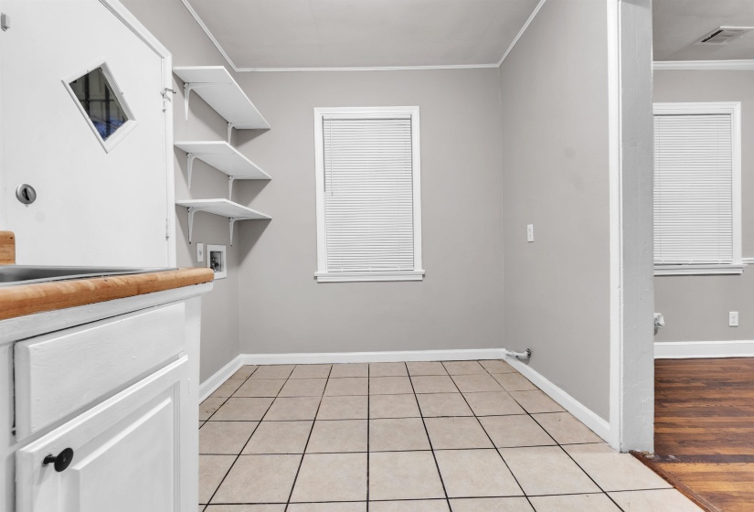 Laundry area with light tile patterned floors, crown molding, and hookup for a washing machine