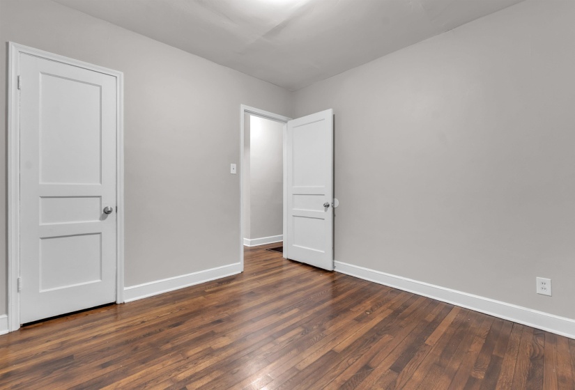 Unfurnished bedroom with baseboards and dark wood finished floors