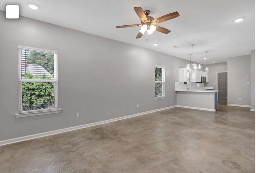 Unfurnished living room with finished concrete floors, recessed lighting, and a ceiling fan