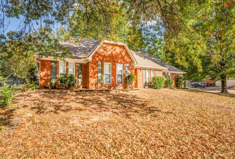Ranch-style house featuring a shingled roof and brick siding
