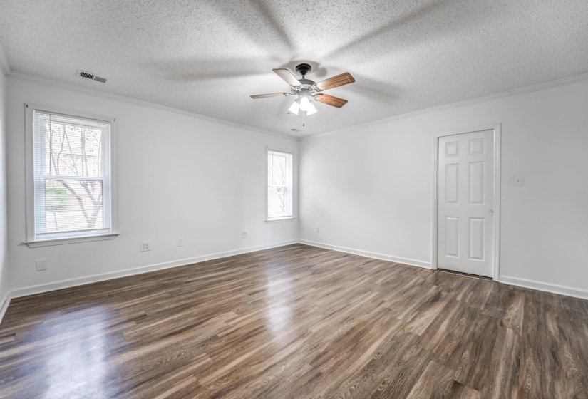 Spare room featuring crown molding, dark wood-style flooring, a textured ceiling, and ceiling fan