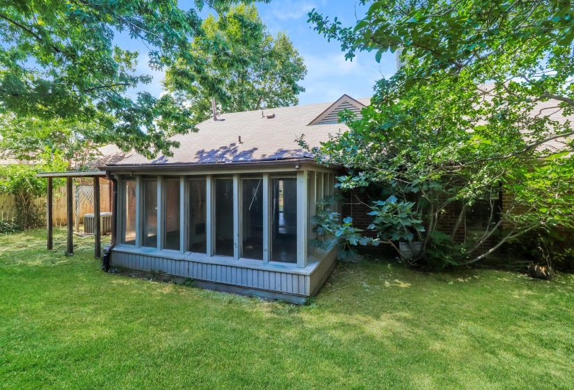 Back of property with a sunroom and a shingled roof