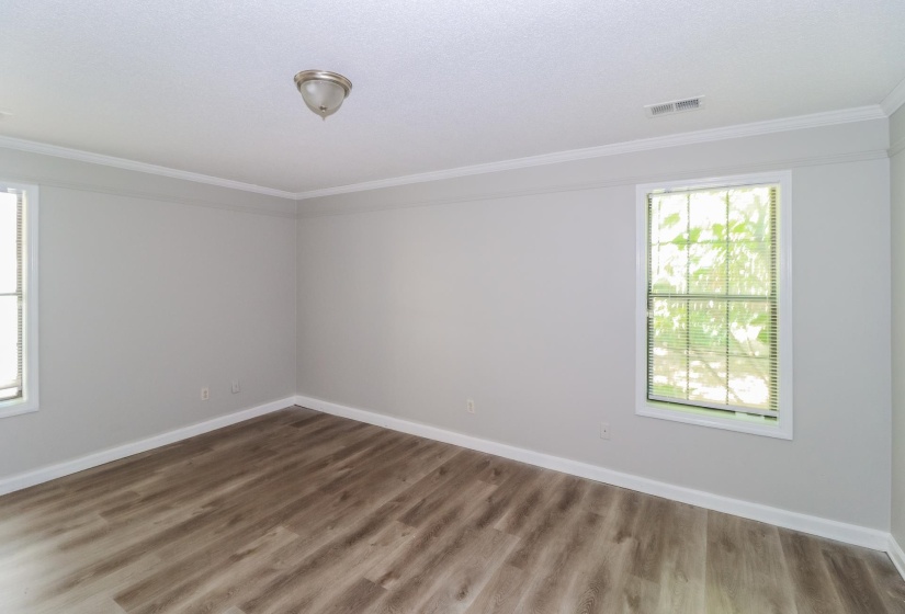 Empty room featuring ornamental molding and wood finished floors