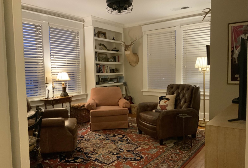 Sitting room featuring built in features and wood finished floors