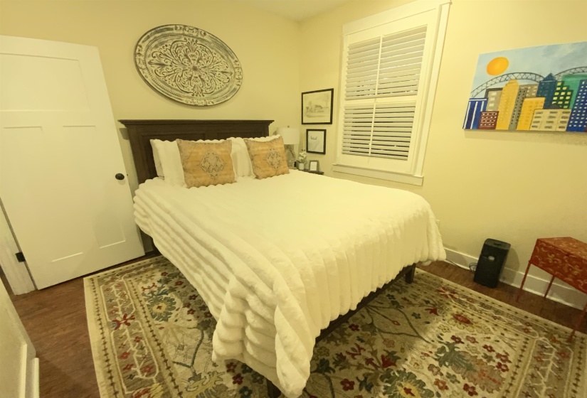 Bedroom with dark wood finished floors and baseboards