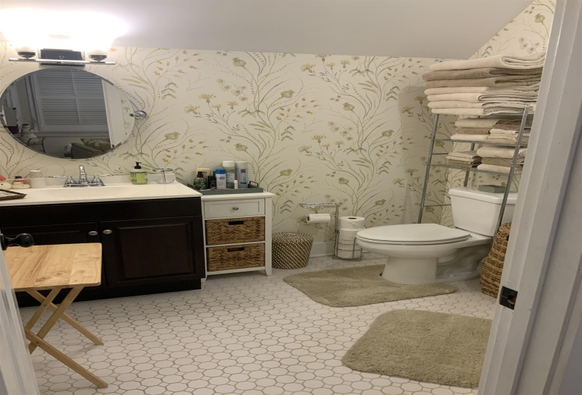 Half bath featuring vanity and wallpapered walls