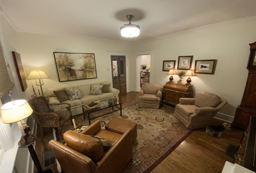 Living room featuring ornamental molding and wood finished floors