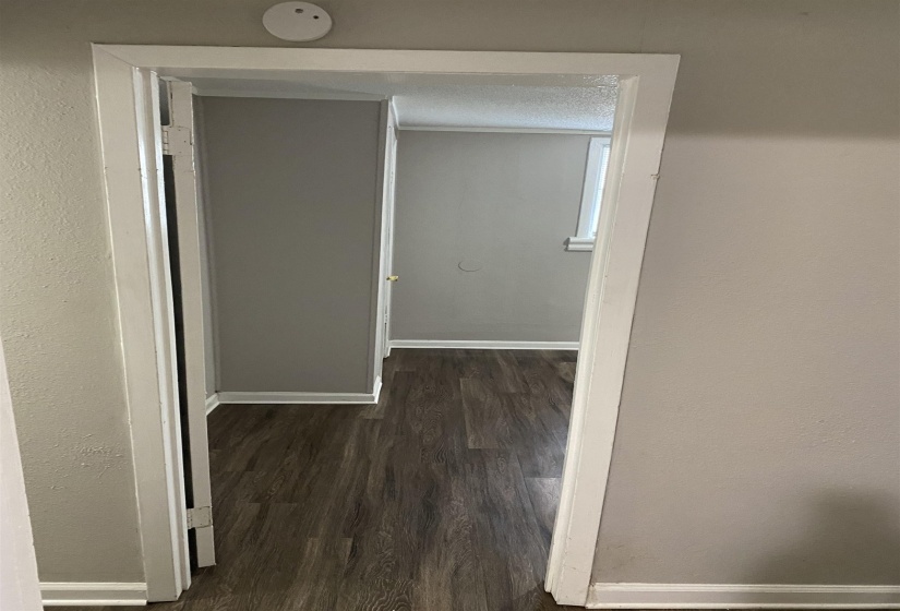 Corridor with dark wood-style flooring, a textured wall, and a textured ceiling