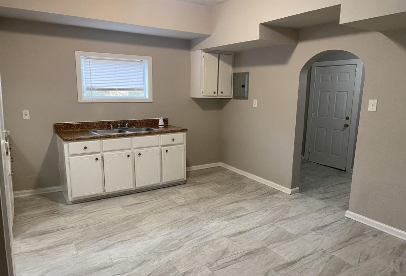 Laundry room featuring arched walkways and electric panel