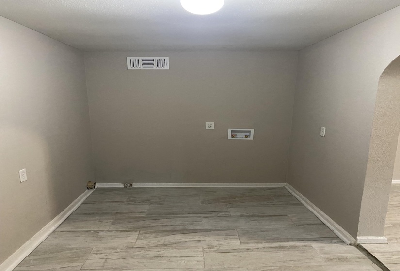 Laundry area with arched walkways and washer hookup