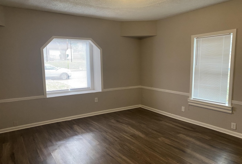 Unfurnished room with dark wood-style flooring and a textured ceiling
