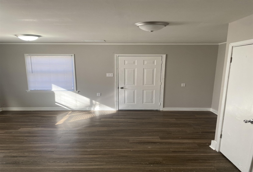 Foyer featuring dark wood-type flooring and crown molding