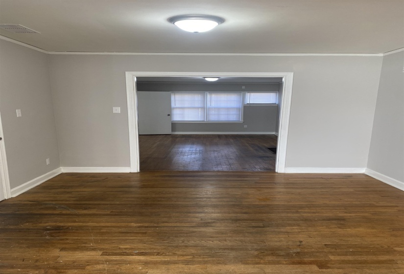Spare room with dark wood-style flooring and crown molding
