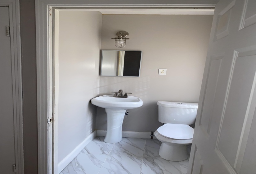 Bathroom with light marble finish flooring and toilet