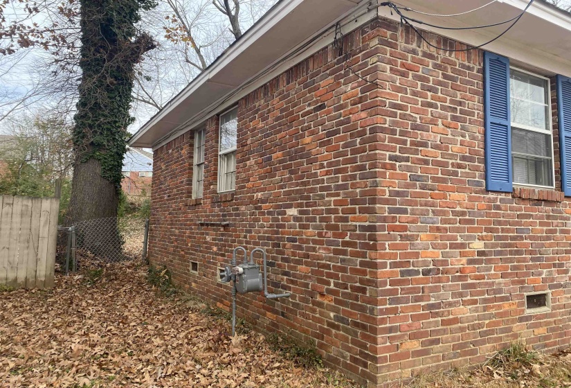 View of side of property featuring crawl space and brick siding