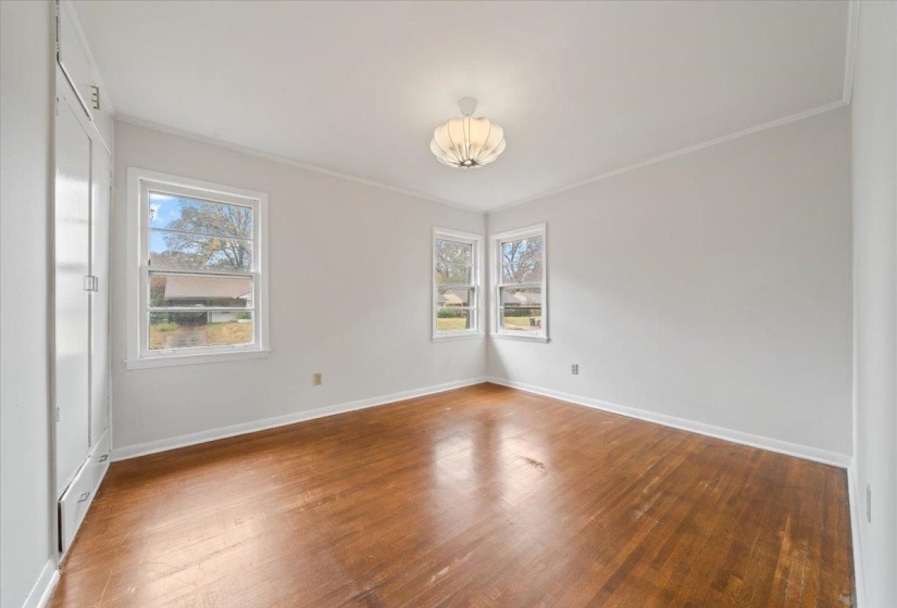 Empty room featuring hardwood / wood-style floors and crown molding