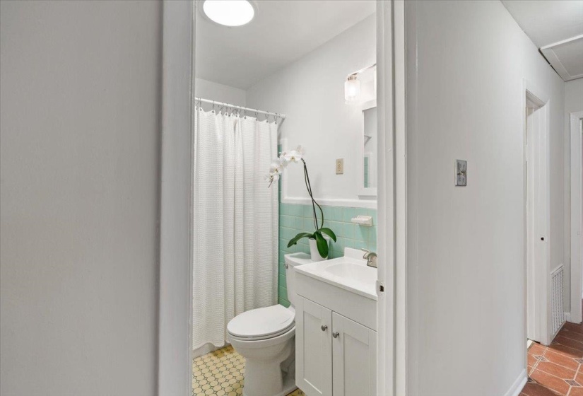 Full bath featuring curtained shower, vanity, a wainscoted wall, and tile walls