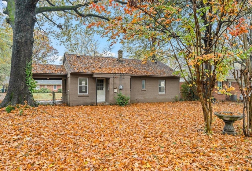 View of front of property featuring a chimney and brick siding