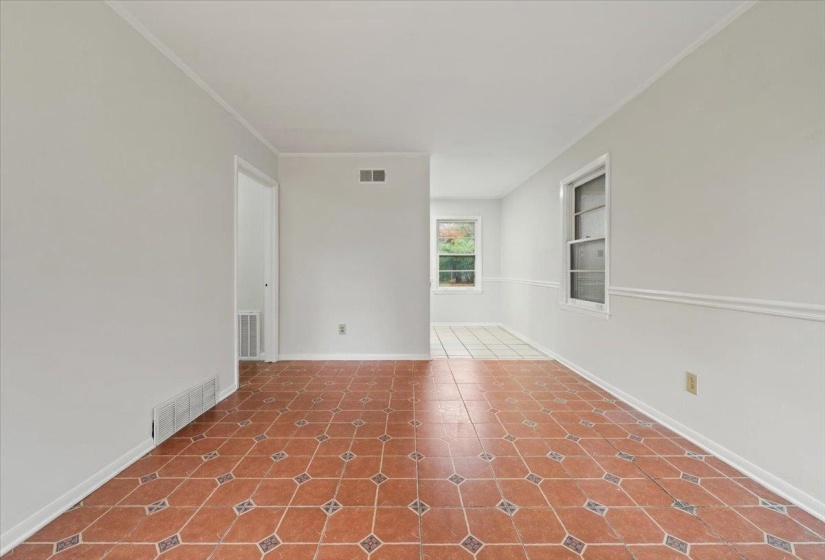 Unfurnished room featuring built in features, crown molding, and tile patterned flooring