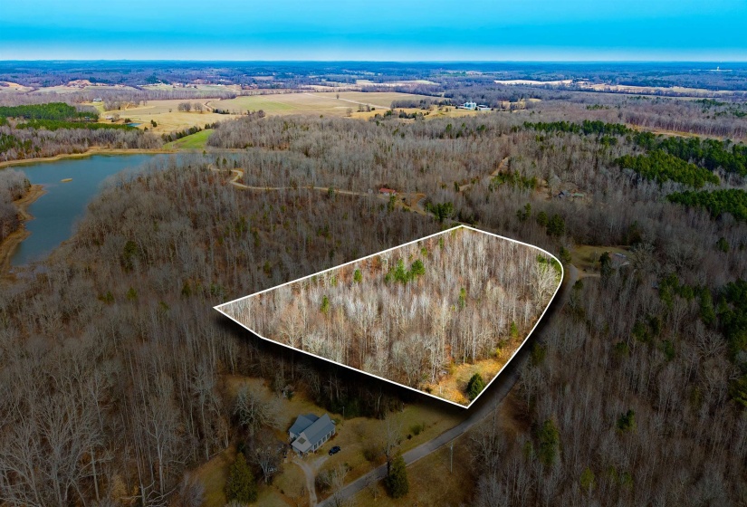 Aerial view of property and surrounding area featuring a large body of water and property boundaries highlighted