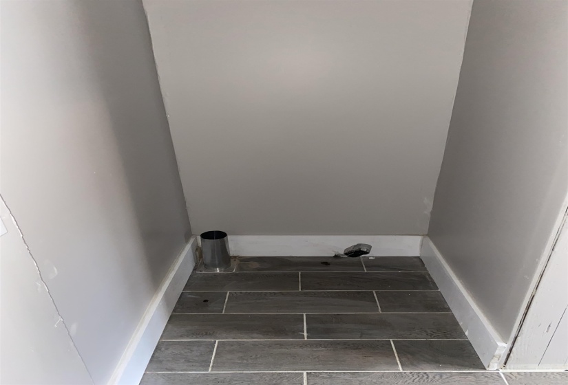 Laundry room featuring baseboards and wood tiled floors