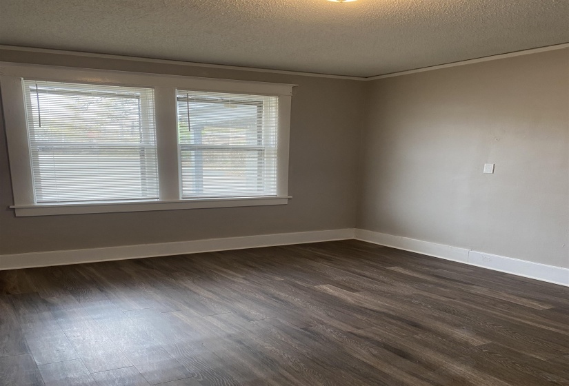 Unfurnished room featuring a textured ceiling and dark wood-type flooring